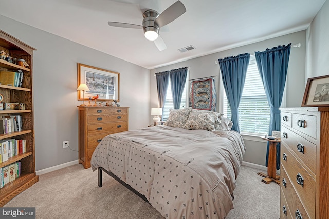bedroom with baseboards, visible vents, light carpet, and multiple windows