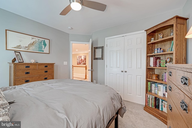 carpeted bedroom with ceiling fan and a closet