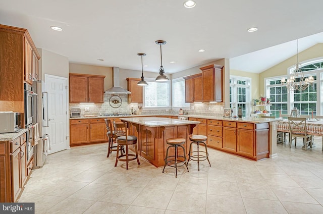kitchen with brown cabinetry, decorative backsplash, wall chimney range hood, and oven