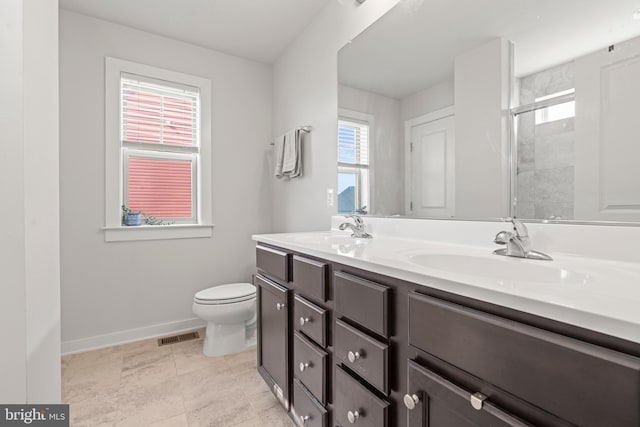 full bath featuring a sink, baseboards, a tile shower, and toilet
