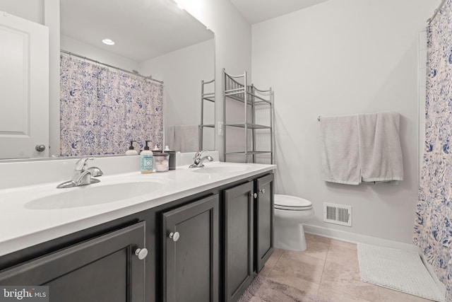 bathroom with visible vents, a sink, double vanity, and toilet