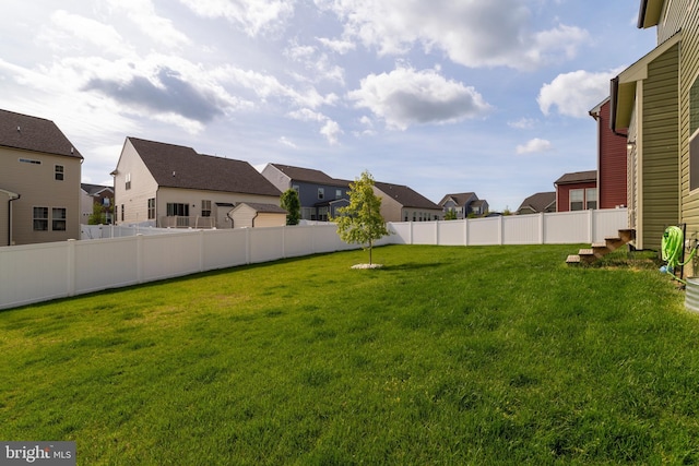 view of yard featuring fence and a residential view
