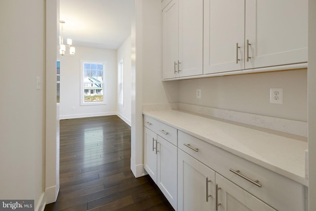 interior space featuring dark wood-style flooring and baseboards