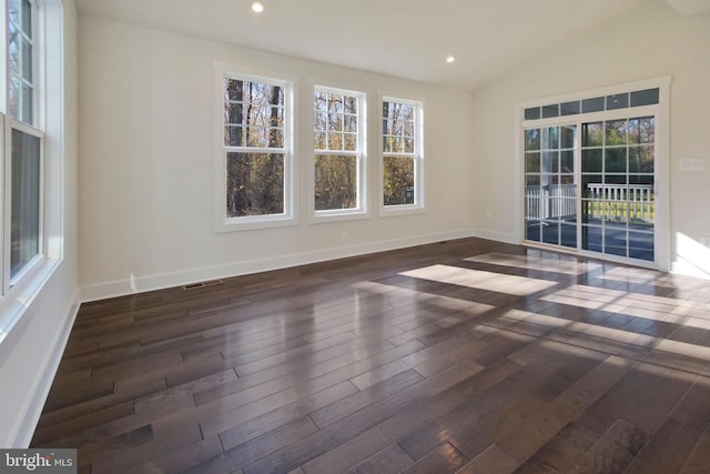 unfurnished room featuring plenty of natural light, visible vents, and hardwood / wood-style flooring