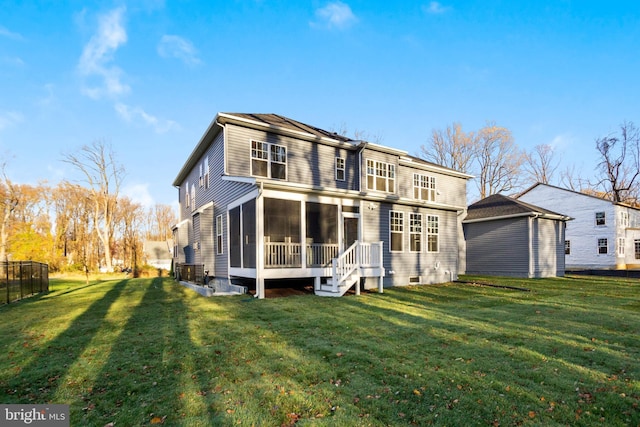rear view of property with a sunroom, fence, and a yard