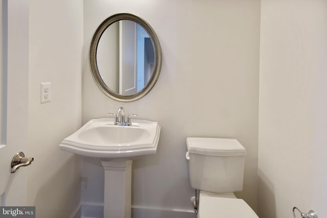 bathroom with baseboards and toilet