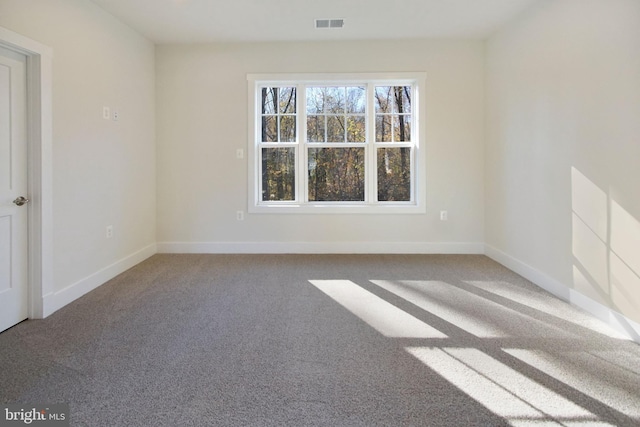 carpeted empty room featuring baseboards and visible vents