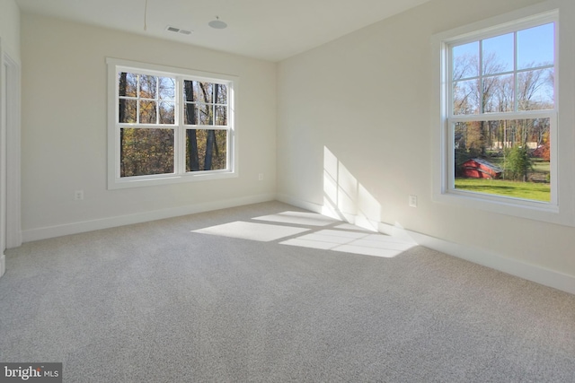 empty room with baseboards, carpet flooring, and visible vents