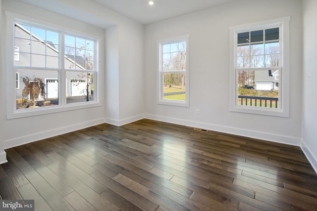 empty room featuring recessed lighting, baseboards, visible vents, and dark wood finished floors