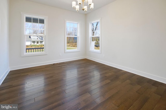 unfurnished dining area with plenty of natural light, baseboards, a notable chandelier, and dark wood-style floors