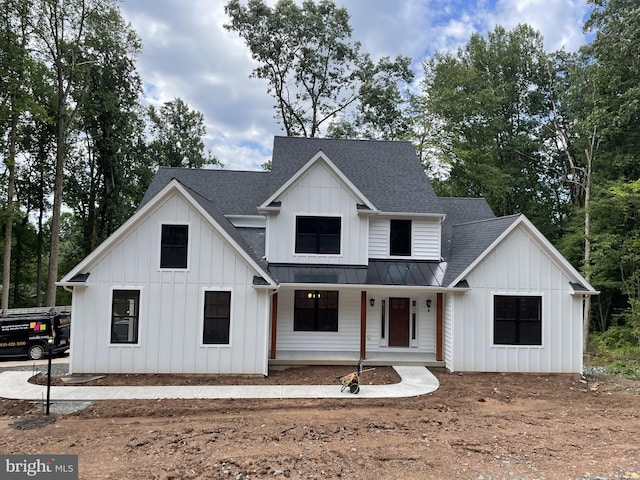 modern inspired farmhouse featuring board and batten siding, a porch, a standing seam roof, metal roof, and roof with shingles