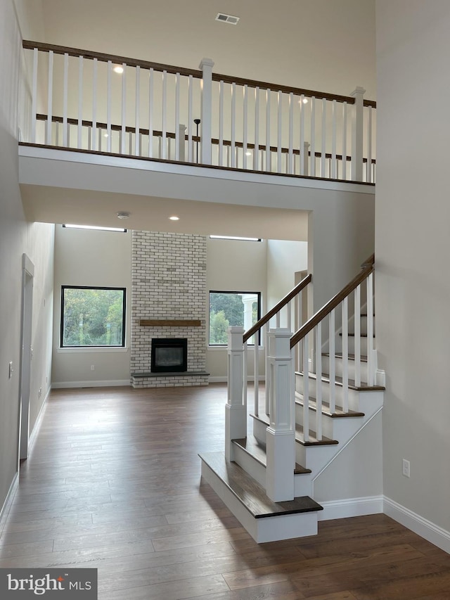 staircase with baseboards, a high ceiling, and a healthy amount of sunlight