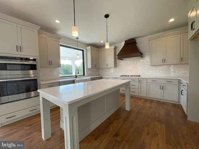kitchen featuring light countertops, tasteful backsplash, custom exhaust hood, and recessed lighting