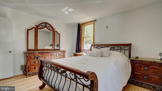 bedroom featuring light wood-style floors and visible vents