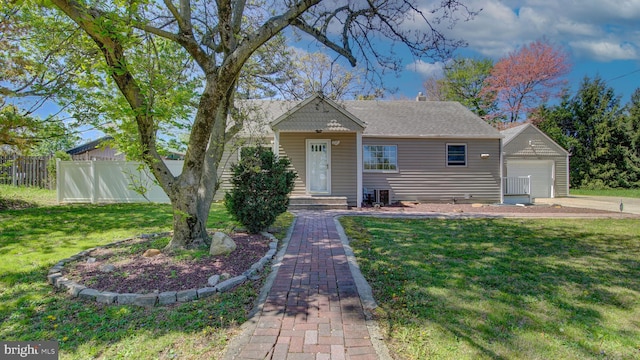 bungalow-style house with fence, an outbuilding, and a front yard