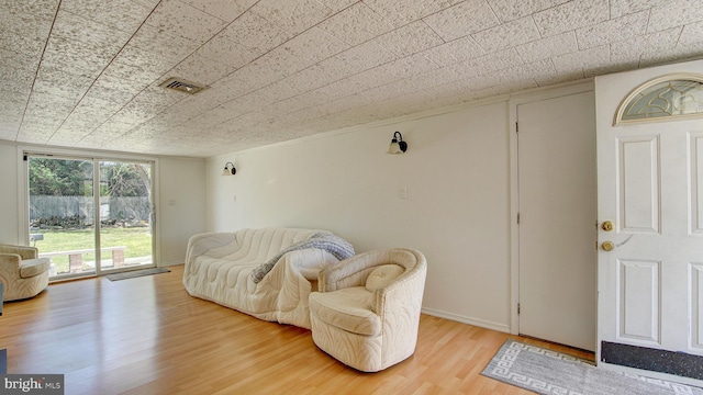 living area featuring visible vents and wood finished floors