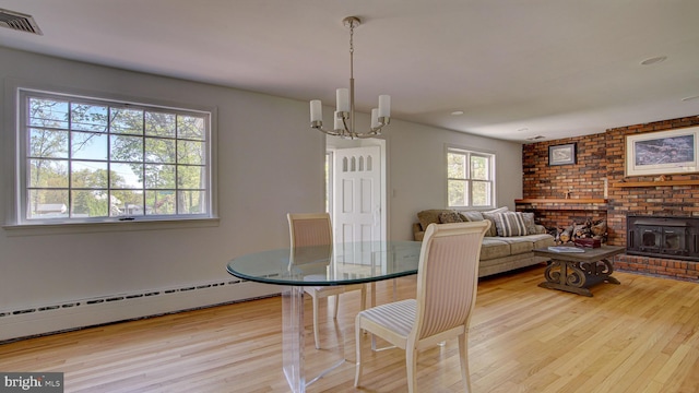dining space with a notable chandelier, recessed lighting, wood finished floors, a baseboard radiator, and visible vents