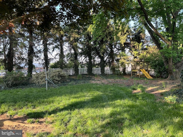 view of yard featuring fence and a playground