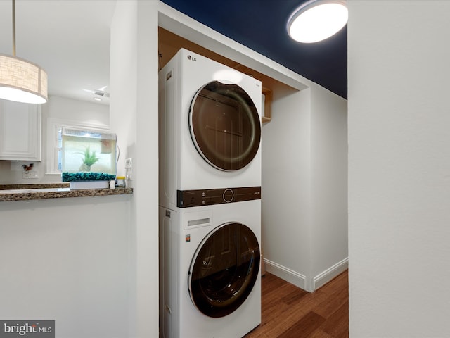 1904 N Amelia St, Sterling, VA 20164 - washroom featuring stacked washer and clothes dryer, wood finished floors, and baseboards