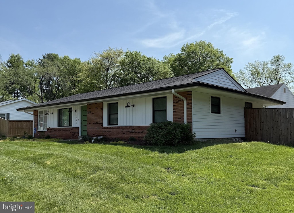 single story home with fence, a shingled roof, a front lawn, and brick siding
