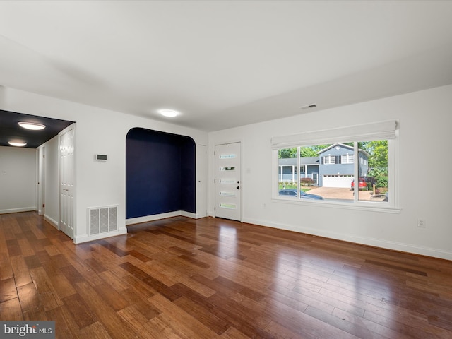 1904 N Amelia St, Sterling, VA 20164 - unfurnished living room featuring arched walkways, hardwood / wood-style floors, and baseboards