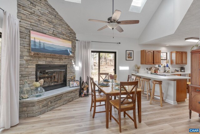 dining room featuring a wealth of natural light, light wood finished floors, and a fireplace
