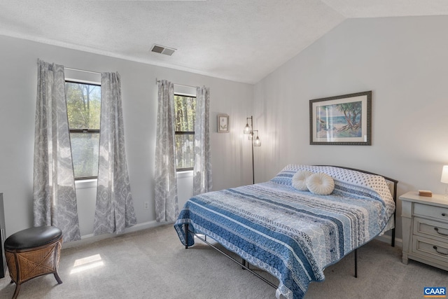 carpeted bedroom with baseboards, visible vents, and vaulted ceiling