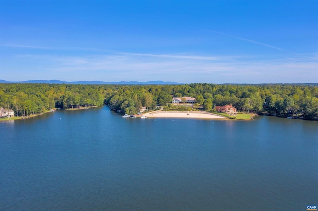 drone / aerial view featuring a water view and a wooded view