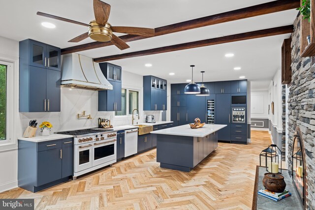 kitchen with premium range hood, blue cabinets, white appliances, and tasteful backsplash