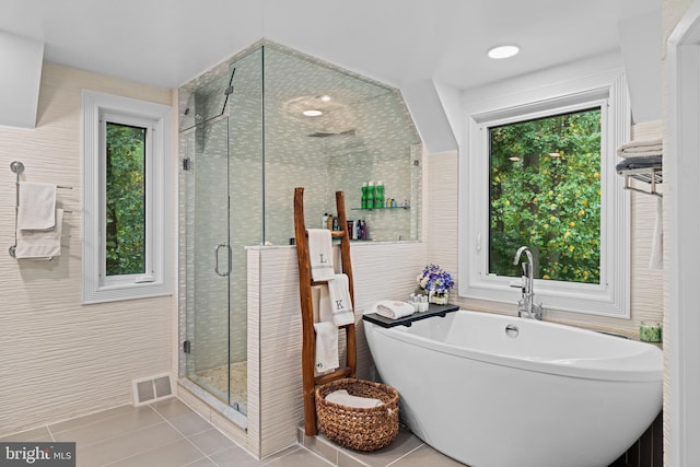 full bathroom with visible vents, tile patterned flooring, tile walls, a freestanding bath, and a shower stall
