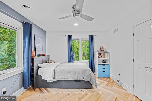 bedroom with baseboards, visible vents, and multiple windows