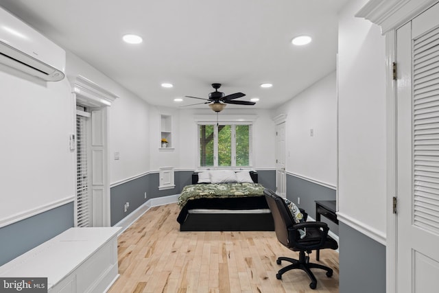 bedroom with recessed lighting, a ceiling fan, light wood finished floors, and a wall mounted air conditioner