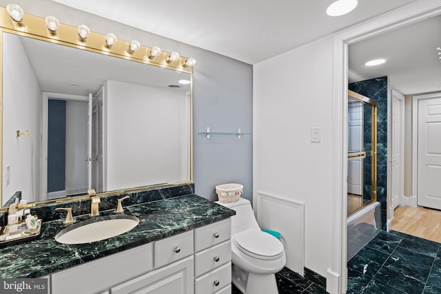 bathroom with toilet, a shower stall, and vanity