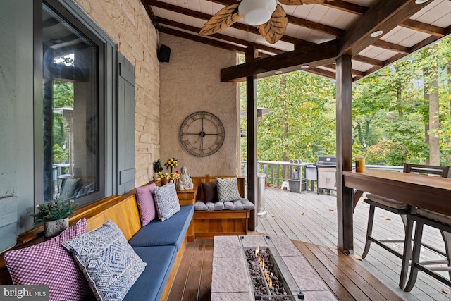 deck with an outdoor living space with a fire pit and ceiling fan