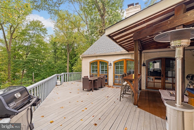 wooden terrace featuring outdoor dining area and grilling area