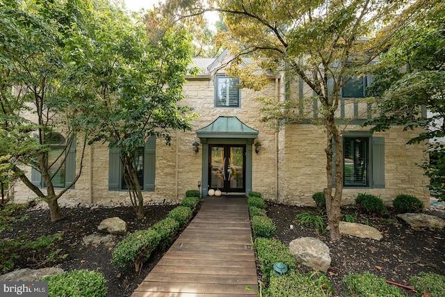 property entrance featuring french doors and stone siding