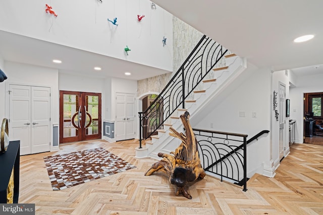 foyer entrance featuring a towering ceiling, baseboards, stairway, recessed lighting, and french doors