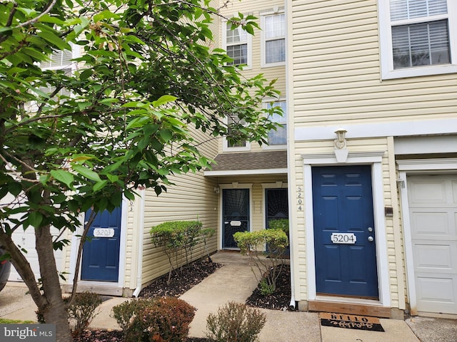 entrance to property with roof with shingles