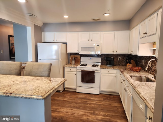 kitchen featuring a sink, dark wood finished floors, white appliances, and white cabinetry