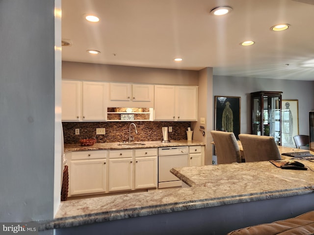 kitchen featuring light stone counters, tasteful backsplash, white cabinetry, and dishwasher
