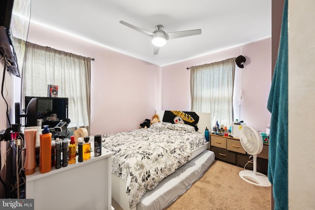 carpeted bedroom with a ceiling fan and multiple windows