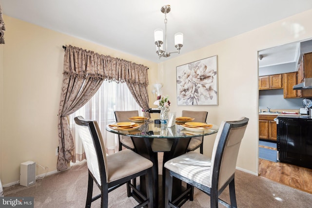 dining room featuring an inviting chandelier, light carpet, and baseboards