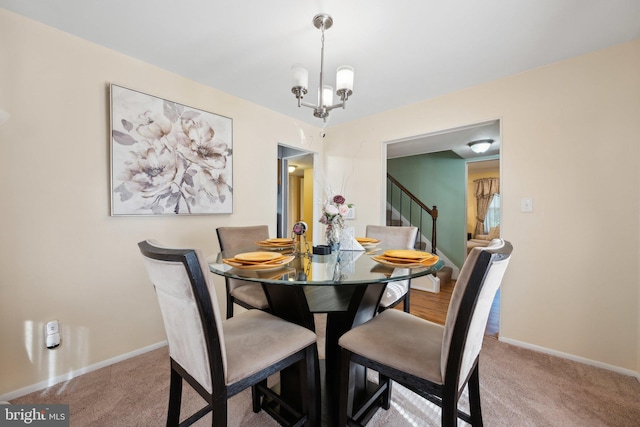 carpeted dining area with baseboards, stairs, and an inviting chandelier