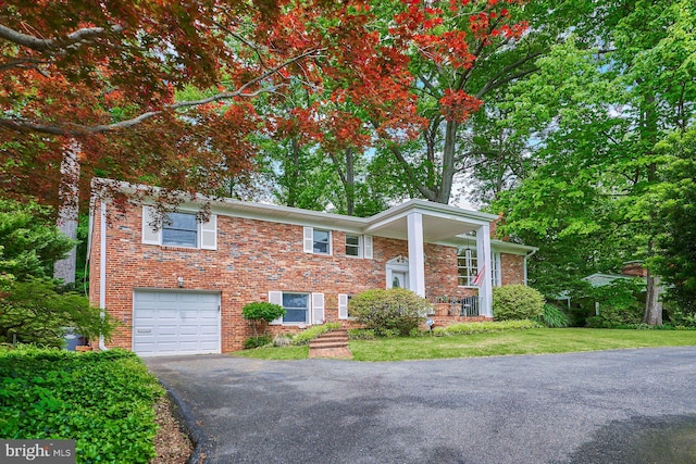6368 Waterway Dr, Falls Church, VA 22044 - view of front of property featuring asphalt driveway, a garage, brick siding, and a front lawn