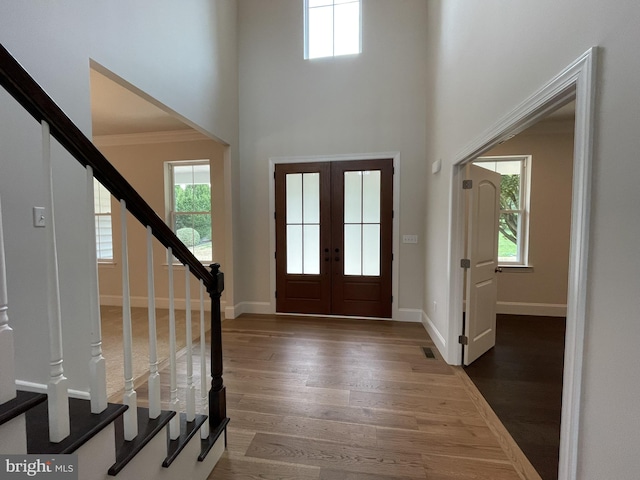 foyer with stairway, wood finished floors, and a healthy amount of sunlight