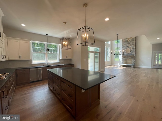 1605 Canary Rd, Quakertown, PA 18951 - kitchen featuring dark countertops, light wood-type flooring, appliances with stainless steel finishes, backsplash, and a notable chandelier