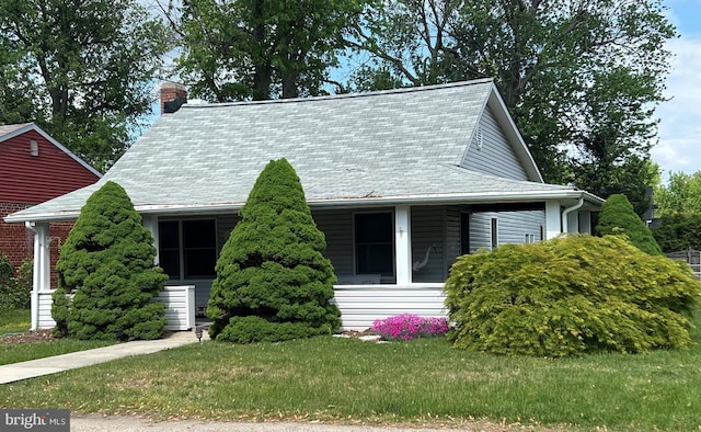 view of front of house with a chimney and a front yard