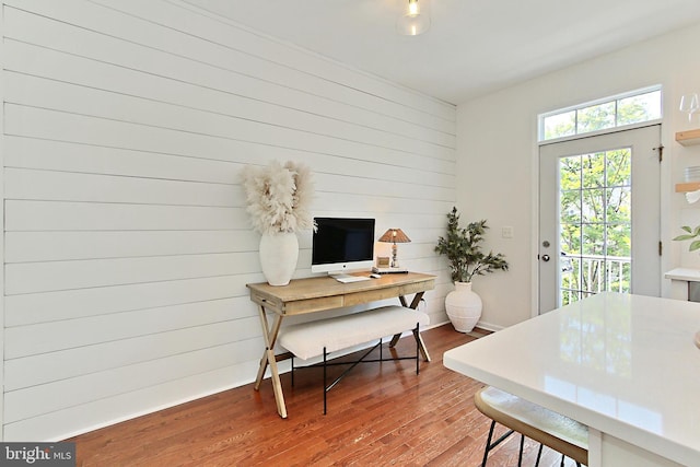 home office with wood walls and wood finished floors