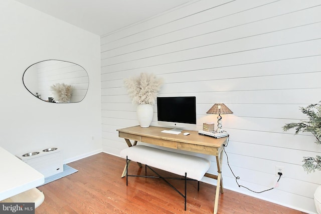 office featuring baseboards, wood finished floors, and wooden walls