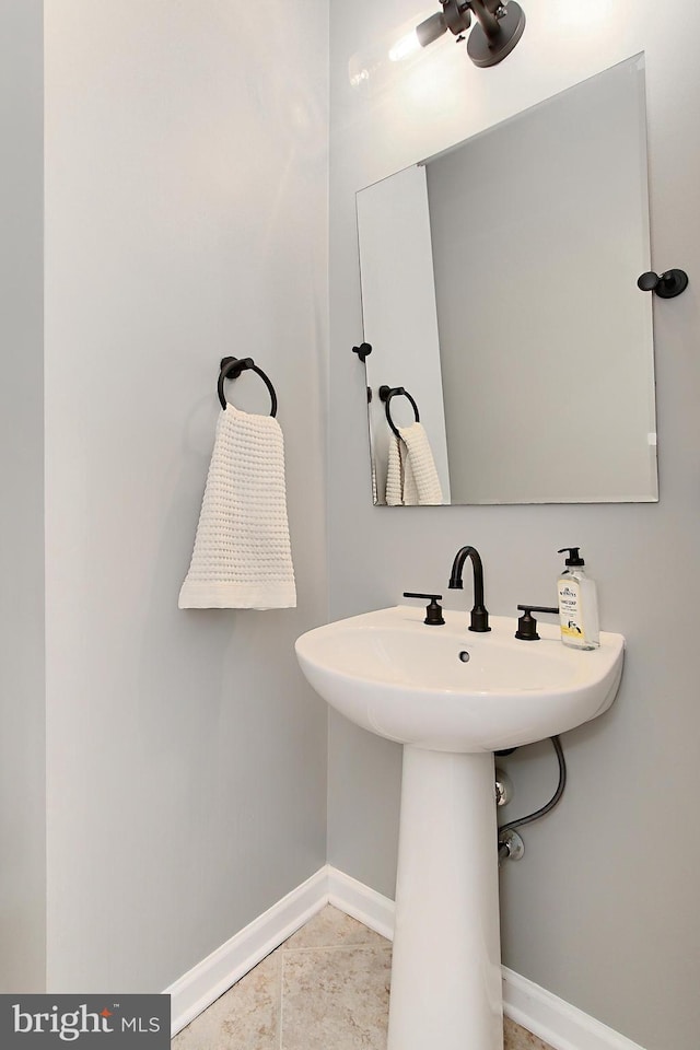bathroom with a ceiling fan and baseboards